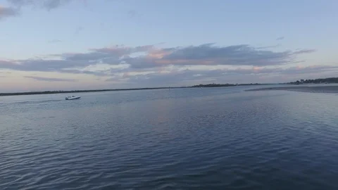 Small Boat leaving Dock into the Sunset Stock-Footage 98945495