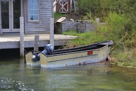 A small boat with motor pulled onshore Stock Photos