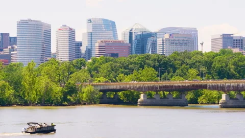 Small boat navigates the Potomac River with the modern skyline of Arlington Stock Footage 310857981