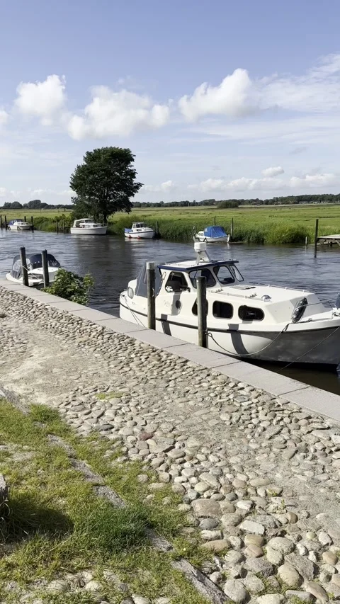 Small boat navigating canal locks with cobblestone path and lush greenery Stock Footage 317774919
