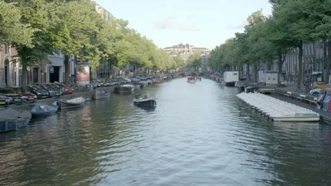 Small Boat Navigating Historic Amsterdam Canal Stock Footage 344603741