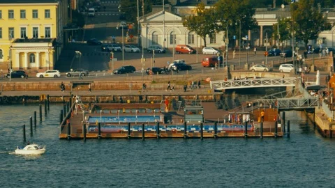 A small boat passes in front of a floating swimming area in downtown Stock Footage 111289701