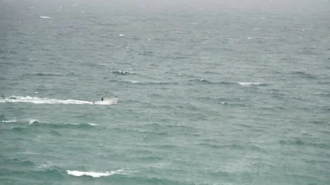 Small boat riding on rough ocean waves in slow motion medium shot Stock Footage 213131515