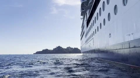 Small boat rocking on waves beside huge cruise ship hull near Portofino Ital Stock Footage 345961791