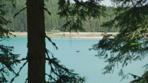 Small boat rowing in a big turquoise colored water lake in Montenegro park Stock Footage 284389588