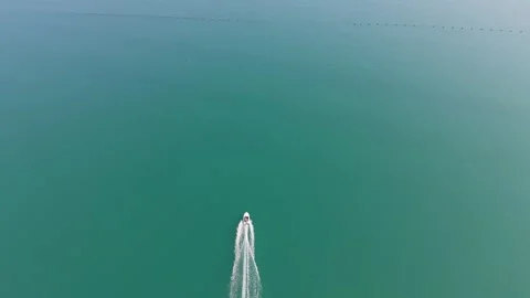 Small boat sailing alone across clear turquoise sea aerial view Stock Footage 330289211
