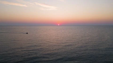 Small Boat Sailing in Calm Sea Water at Golden Sunrise Sunset Stock Footage 340620802