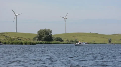 Small boat sailing in a river with windmills in a background Stock Footage 33119538