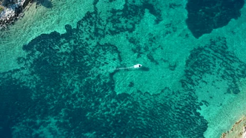 A small boat sails between the islands of the Adriatic Sea Stockbeeldmateriaal 165929894