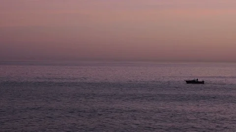 Small boat sails on the calm sea after sunset Stock Footage 100241268