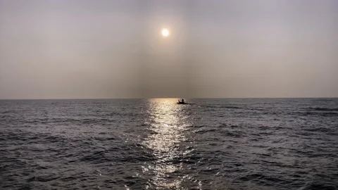 A small boat sails on the sea at sunset, a fishing boat sails in the ocean Stock Footage 219121497