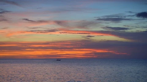 Small boat in sunset ocean with small waves and dark blue sky Stock Footage 113273414