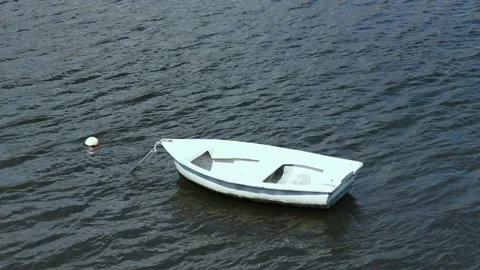 A small boat sways lonely in a river. Stock Footage 131402468