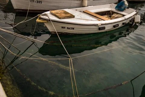 Small boat tied up on jetty Stock Photos