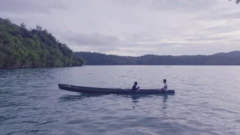 Small Boat with Two People on Calm Sea in Tropical Coastal Village Indonesia Vídeos de archivo 333082117