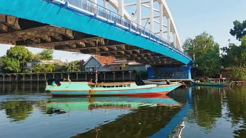 A small boat under a large bridge Stock Footage 318715971