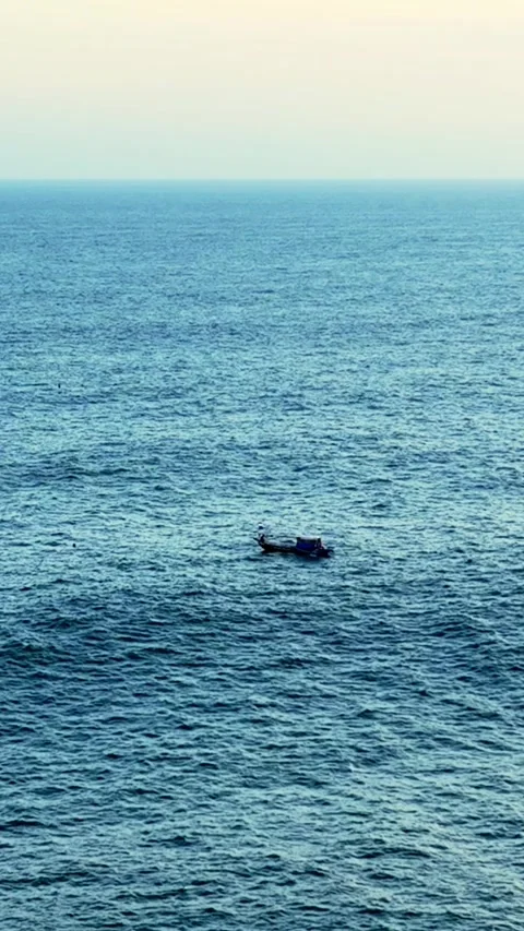 Small boat on vast blue ocean Stock Footage 335432672
