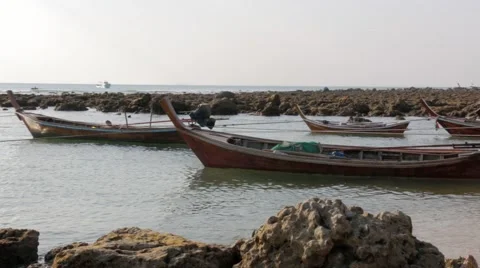 Small boats float attached to ropes at a local shore in Thailand Stock Footage 51035109