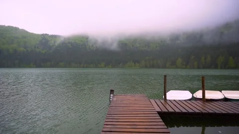Small boats floating on the mountain forest lake close to the wooden pier. Stock-Footage 150593708