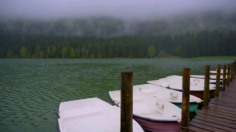 Small boats floating on the mountain forest lake close to the wooden pier. Stock Footage 150593793