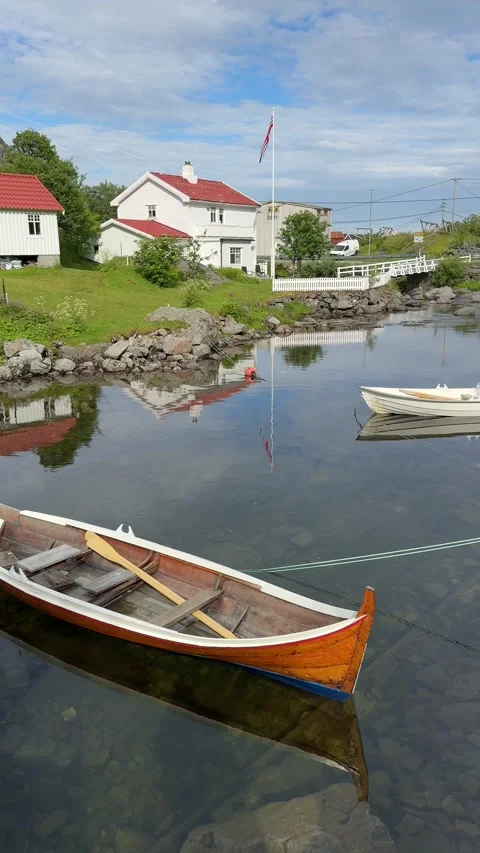 Small boats resting on calm mountain lake Aagvatnet near the village of A Stock Footage 332875385