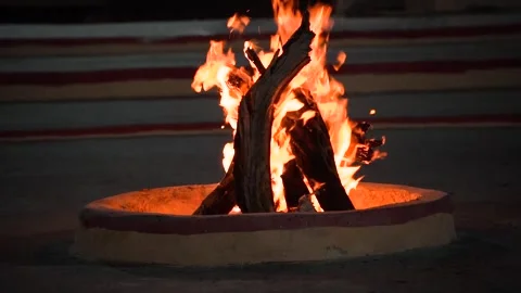 Small bonfire made of logs in a brick firepit showing camping in the desert in Stock Footage 267214326