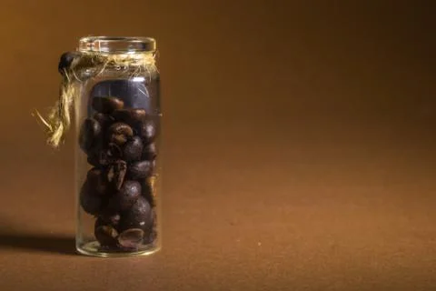 A small bottle with coffee beans on a brown background Stock Photos