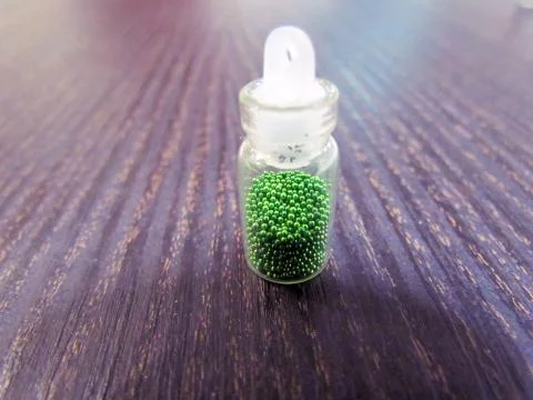 Small bottle with a decorative material for nail design Stock Photos