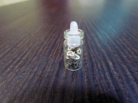 Small bottle with a decorative material for nail design Stock Photos
