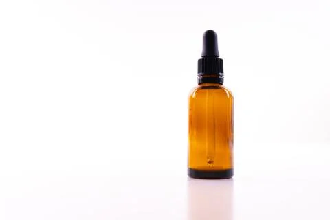 A small bottle with a dropper full of CBD oil or any other oil on white backg Stock Photos