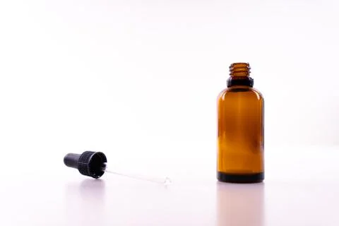 A small bottle with a dropper full of CBD oil or any other oil on white backg Stock Photos