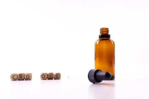 A small bottle with a dropper full of CBD oil or any other oil on white backg Stock Photos