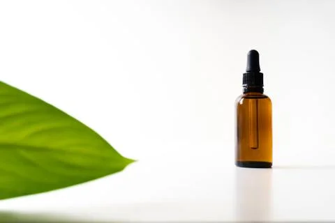 A small bottle with a dropper full of CBD oil or any other oil and a green le Stock Photos