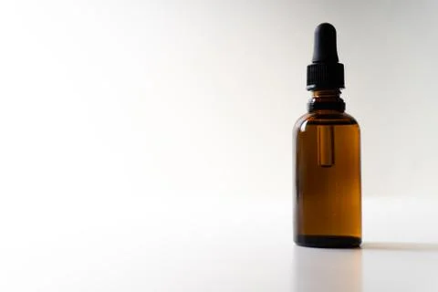 A small bottle with a dropper full of CBD oil or any other oil on white backg Stock Photos