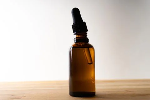 A small bottle with a dropper full of CBD oil or any other oil standing on a  Stock Photos