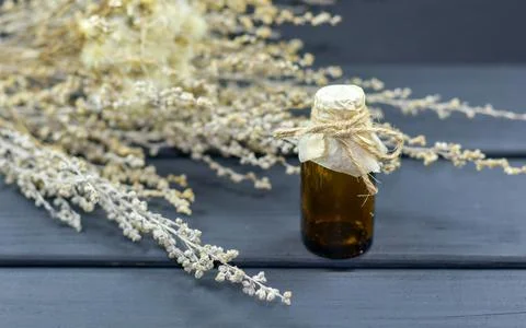 A small bottle with herbs on background. Stock Photos