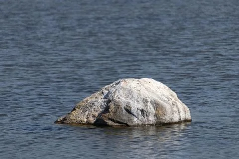 Small boulder protruding from sea water on the Gulf of Riga Stock Photos