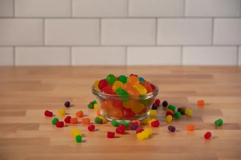 Small bowl of asserted sweet candy treats on butcher wood table Stock Photos