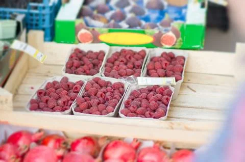 Small boxes with raspberry on street market Stock Photos