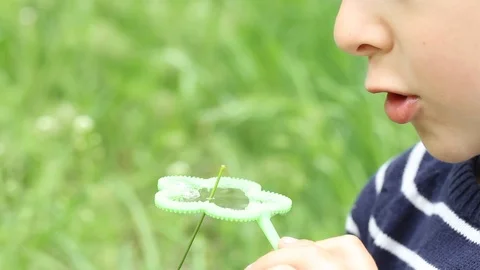 Small boy blowing bubbles. Happy child blowing soap bubbles in spring park. Stock Footage 107251020