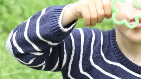 Small boy blowing bubbles. Happy child blowing soap bubbles in spring park. Stock Footage 107251211