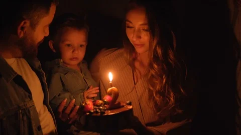 Small boy is blowing out the candle on his awesome birthday cake in a dark room. Video stock 120398640