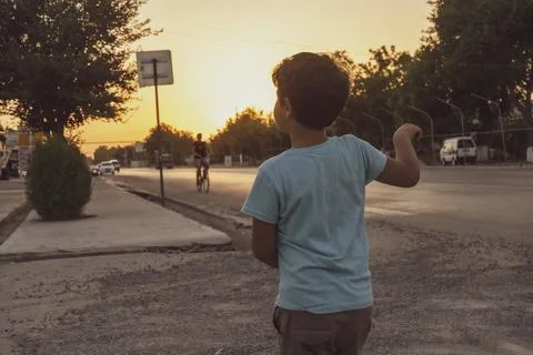 A small boy dancing in a evening road roadside stand Photos