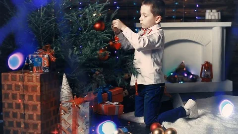 A small boy decorates a Christmas tree Stockbeeldmateriaal 81159594