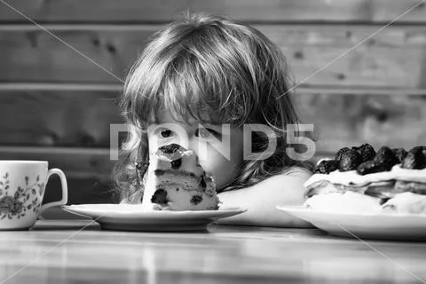 Small boy eats strawberry cake Stock Photos