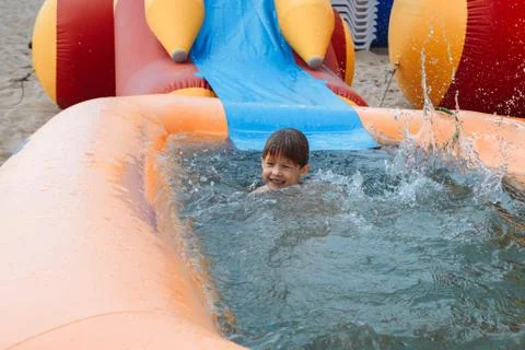 A small boy is happily bathed in an inflatable pool. Stock Photos