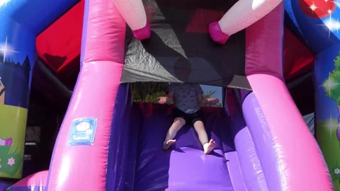 Small Boy having fun playing on a Bouncy Castle Stock Footage 172265577