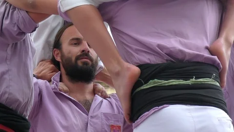 Small boy in helmet slides down human castle top level Stock-Footage 103299913