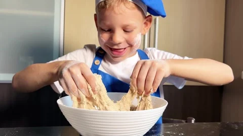 Small boy helping mother prepare dough for baking bread in home kitchen. Stock Footage 285315441