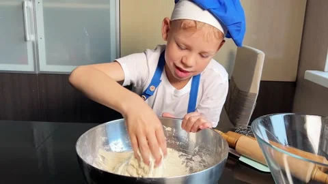 Small boy helping mother prepare dough for baking bread in home kitchen. Home Stock Footage 295188056